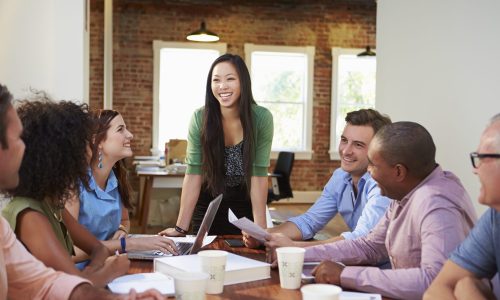 Photo of a group of people sitting around a board room table.