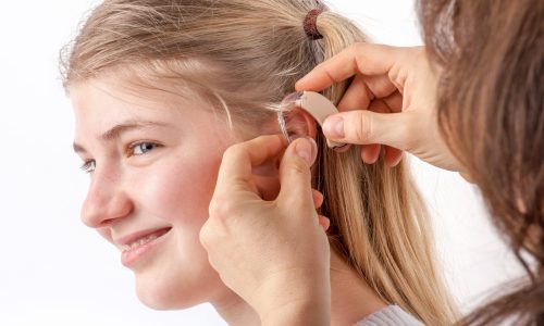 Photo of a young woman with a hearing aid.