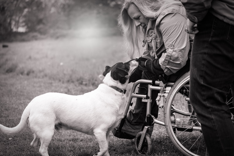 Photo of a woman in a wheelchair with a dog.