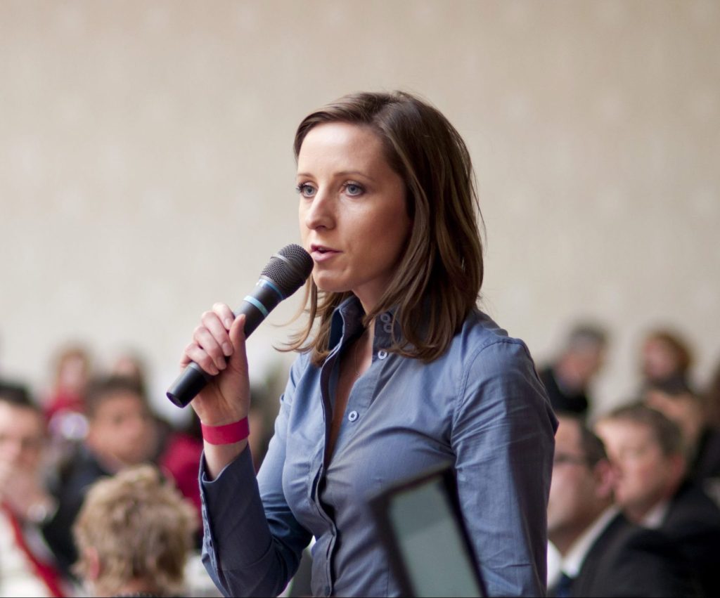 woman speaking into a microhphone.