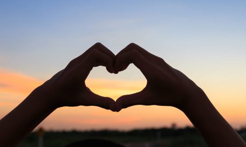 Photo of hands in a love heart shape.