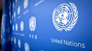 Blue wall with white United Nations logos duplicated across it.