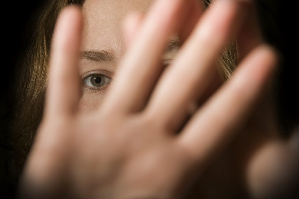 Photo of an indistinguishable person holding their hand up in a stop motion.