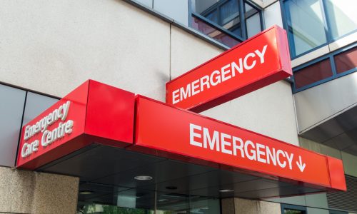 Photo of a red emergency sign on the side of a building.