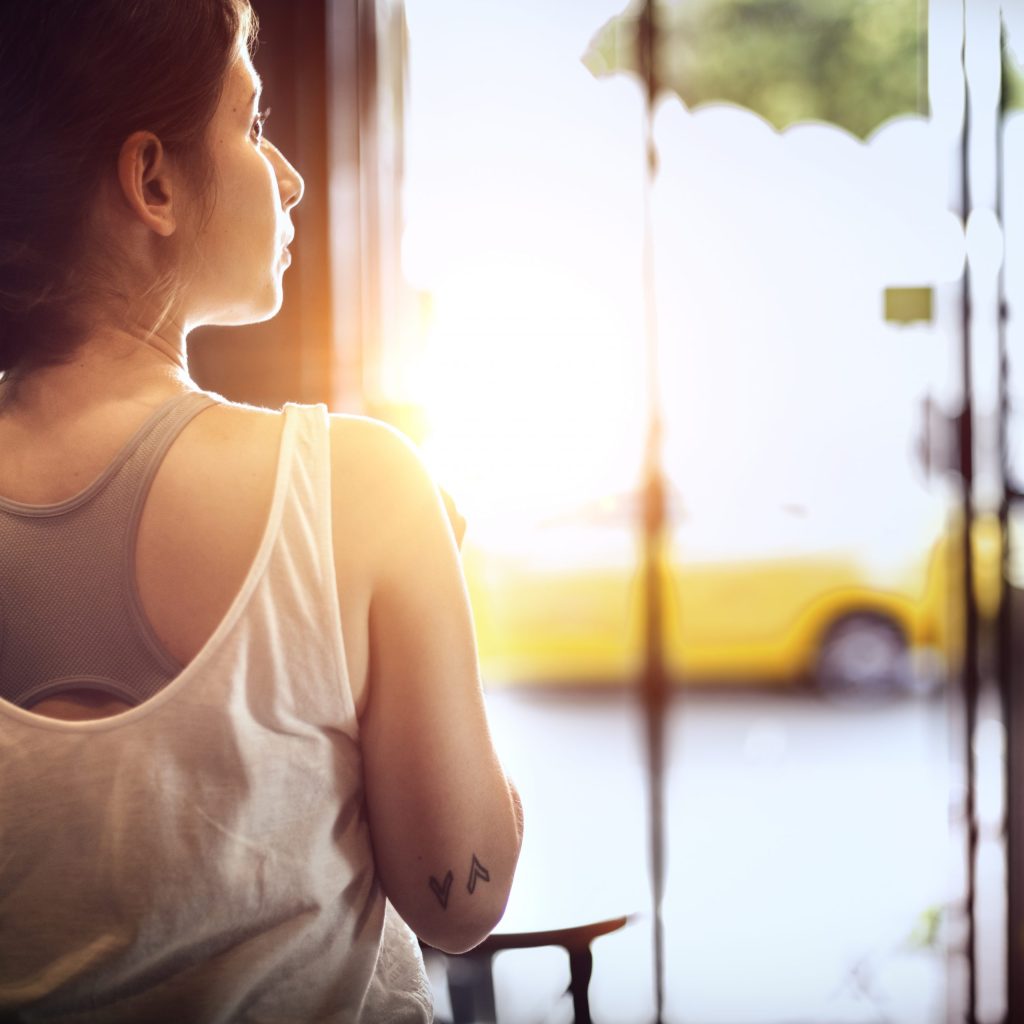 Photo of a woman looking out a window.