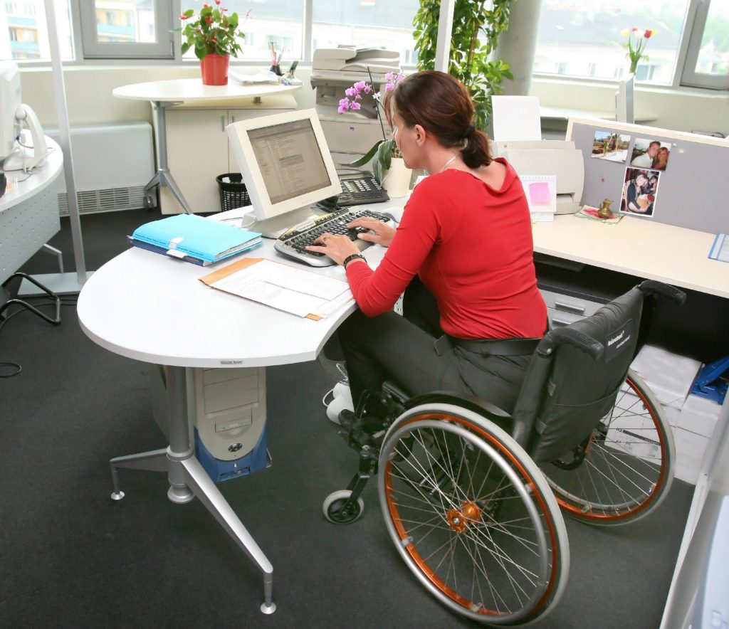 Photo of woman in a wheelchair working at a computer.