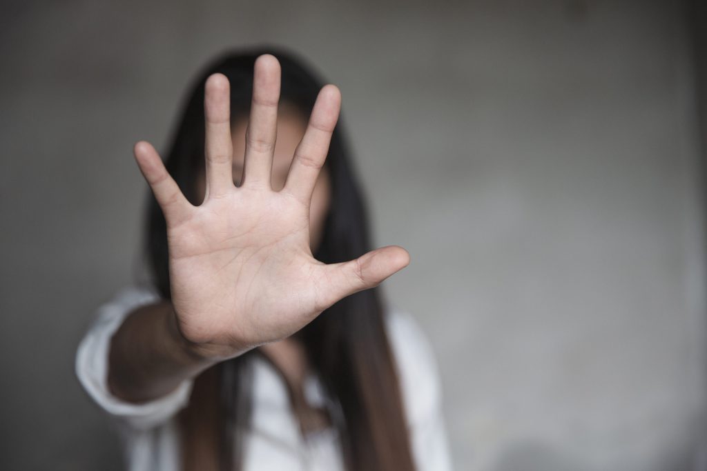 A woman putting her hand up in a stop motion.