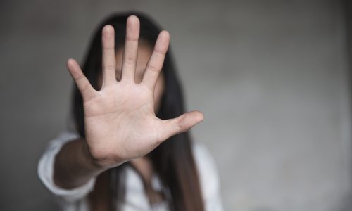 A woman putting her hand up in a stop motion.