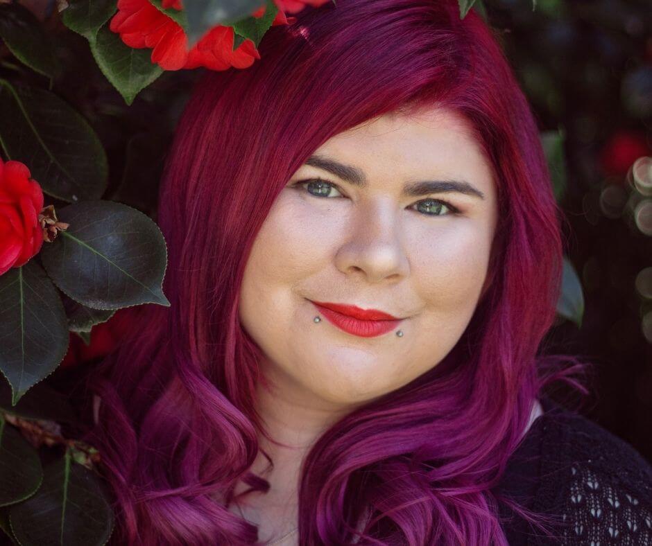 Portrait photo of Zoe, who has white skin and long hair that is a gradient of pink to red.