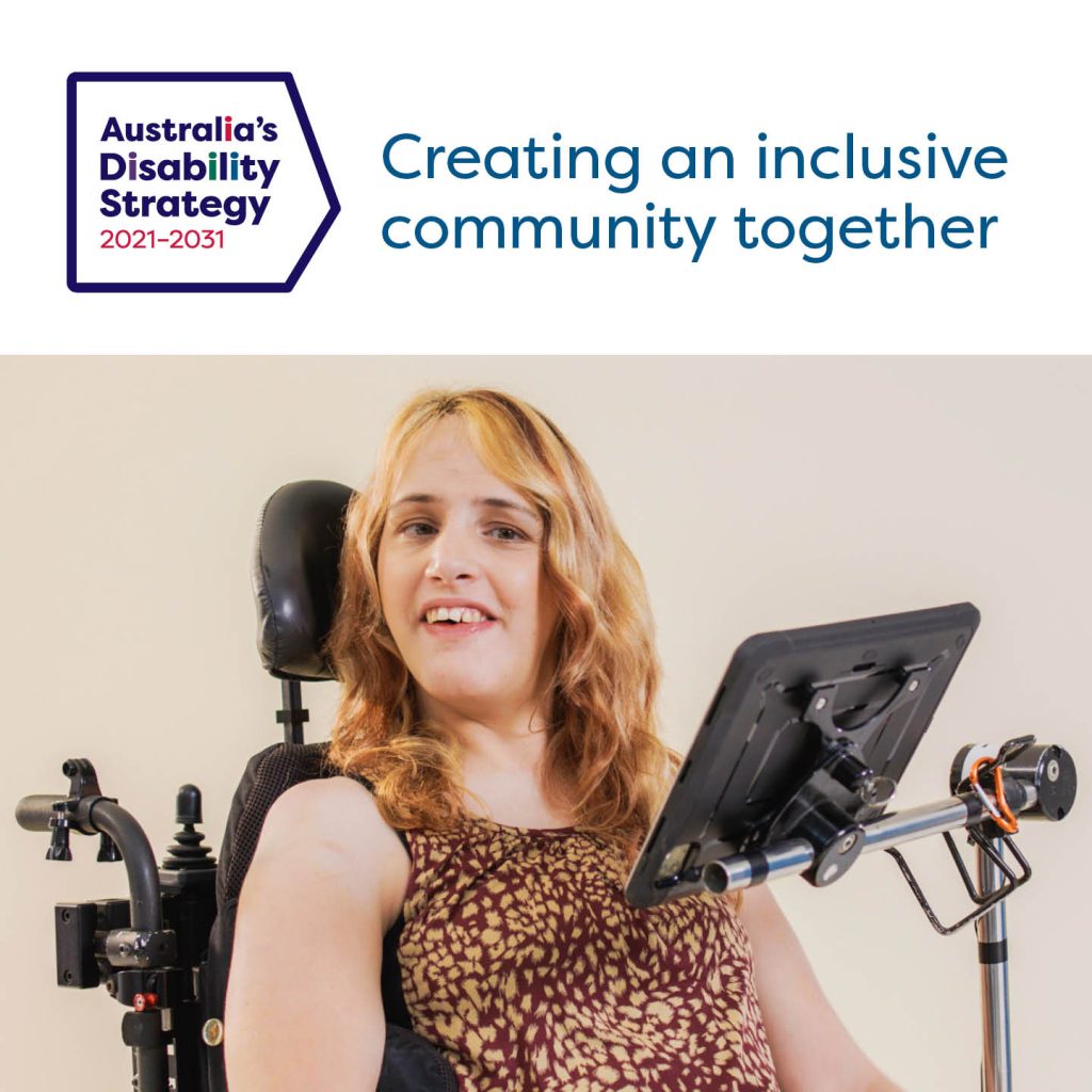 Photo of a woman using an electric wheelchair with a communication device in front of her. She has blonde wavey hair and is wearing a brown and cream top. Above the photo is text: 'Australia's Disability Strategy 2021-2023: Creating an Inclusive Community Together'