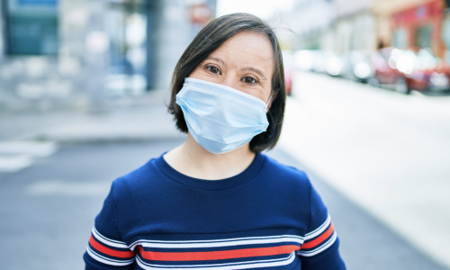 A woman with disability wearing a mask.