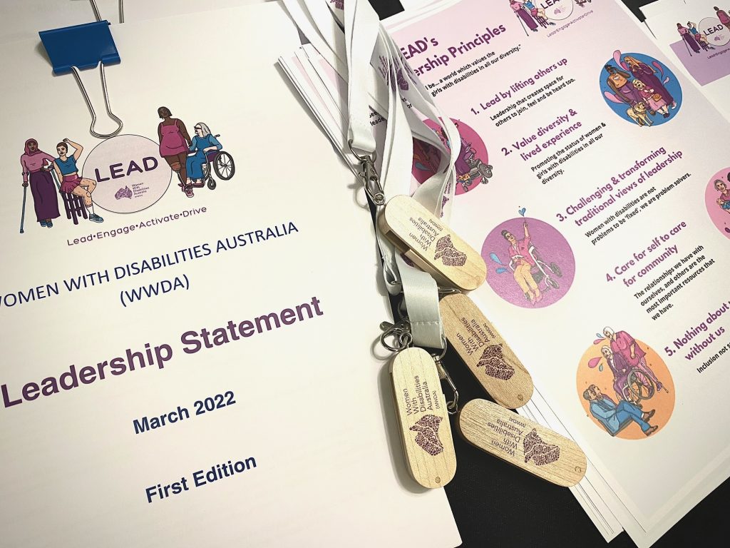 Photo of some of the items on the registration page at the Leadership week. One document is called the Leadership statement and some USB's with the WWDA logo