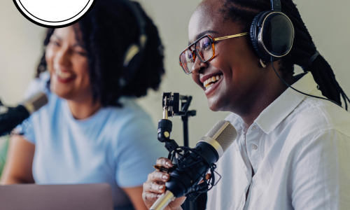 This tile has displays a photo of two women speaking into podcast microphones. The woman on the left has brown skin, a short and curly black hair and is wearing a light blue t-shirt and black headphones. The woman on the right has darker brown skin, black hair styled in tight braids and is wearing a white button up shirt, black and white framed glasses and black headphones. Her hand is holding the microphone. A white circle with a black border that says: "Have your say" is in the top-left corner. A white banner along the bottom of the tile says "Member Skills and Interests"